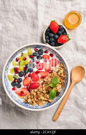 Ciotola con frutti di bosco, frutta e yogurt naturale. Piatto sano ciotola di cereali per la colazione. Vista dall'alto Foto Stock