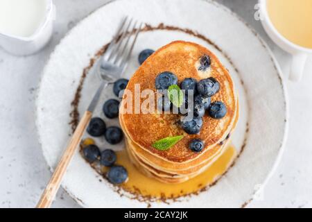 Frittelle con bluberries e sciroppo d'acero dolce su un piatto. Vista dall'alto Foto Stock