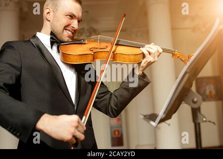giovane caucasico di talento gorgeous man un tux suonare violino, musicista professionista pratica performance, utilizzare strumento classico . concetto musicale Foto Stock