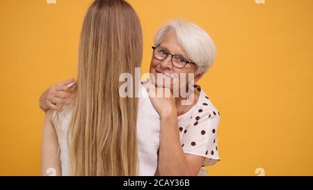 Donna anziana abbracciando giovane ragazza membro della famiglia. Concetto di legame familiare. Foto di alta qualità Foto Stock