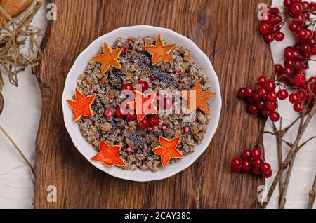 Tradizionale kutya natalizia con arancio candito a forma di stella. Decorazioni in forma di stelle a buccia d'arancia. Foto Stock