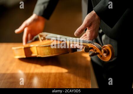 musicista professionista dal taglio irriconoscibile che porta il violino nelle mani, andando ad eseguire musica classica, violinista, concetto musicale Foto Stock