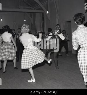 Anni '60, storico, un gruppo di uomini e donne di danza lirica leggera nei loro costumi, gli uomini vestiti come ministeri in bianco e nero, personaggi basati sul Black and White Minstrel Show, un popolare spettacolo di intrattenimento leggero britannico che ha corso per vent'anni sulla televisione della BBC. A partire dal 1958, è stato uno spettacolo settimanale di varietà che ha presentato canzoni tradizionali americane minstrel e country, oltre a brani e numeri di sale. L'opera leggera è una forma di intrattenimento musicale, spesso comico, che coinvolge cantare e ballare e ha una lunga tradizione nel Regno Unito. Foto Stock