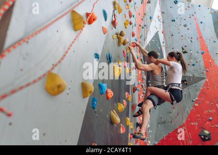 ragazza divertente massaggiando la sua amica mentre la carring su heis indietro durante l'allenamento. vista laterale foto, copia spazio Foto Stock