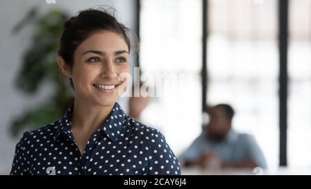 Testa ha girato sorridendo imprenditore indiano sognando e visualizzando Foto Stock