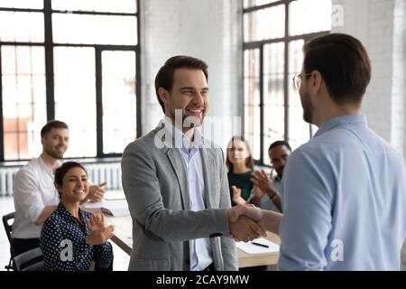 Primo piano leader che ringrazia il dipendente di successo per il buon lavoro, stretta di mano Foto Stock