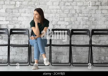 Premuroso sottolineato giovane donna candidato in attesa di colloquio di lavoro Foto Stock