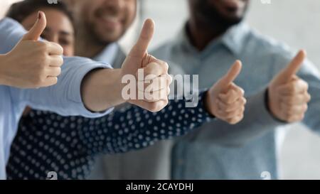 Avvicinati a diversi dipendenti che mostrano i pollici insieme Foto Stock