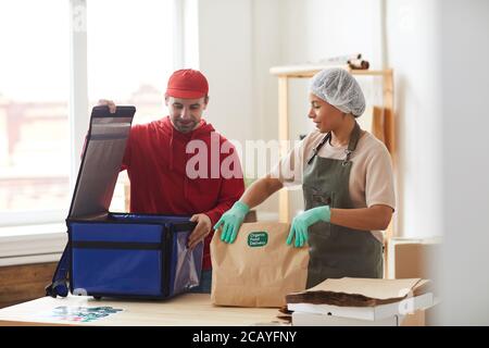 Vita in su ritratto di uomo maturo di consegna ordini di imballaggio per raffreddare scatola al servizio di consegna del cibo, spazio di copia Foto Stock