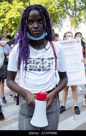 Un dimostratore detiene un megafono durante una protesta contro la questione Black Lives fuori Scotland Yard.i manifestanti chiedono di porre fine all'"over policing of Black Community" e all'uso eccessivo della forza. Foto Stock