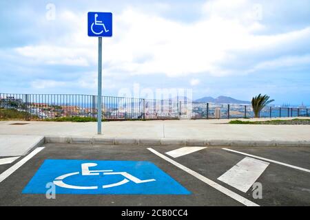 Un posto auto per i conducenti disabili, il simbolo internazionale di accesso (ISA), una persona in sedia a rotelle. Foto Stock