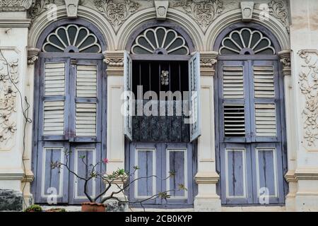 Finestre ad arco e a graticcio su una tradizionale casa in stile sino-portoghese a Yaowarat Road nella zona della Città Vecchia di Phuket, Phuket, Thailandia Foto Stock