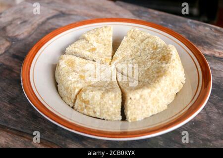 Krasikan è una torta di spuntini tradizionale di Gunung Kidul Indonesia a base di riso glutinoso, latte di cocco, zucchero di canna, cocco grattugiato servito sfondo di legno. Foto Stock