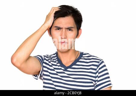 Studio di un giovane uomo asiatico serio isolato contro il bianco sfondo Foto Stock