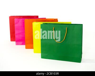 Borsa colorata isolato su sfondo bianco. Fila di sacchetti di carta vuoti di colore multicolore, verde, verde chiaro, arancione, rosa e rosso. Foto Stock