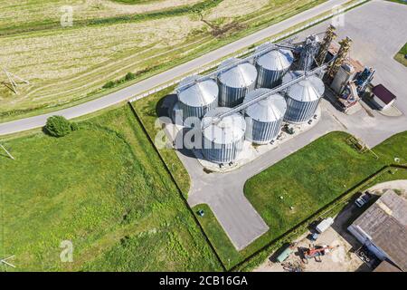 silos argentati per essiccazione e stoccaggio di prodotti agricoli. foto aerea dall'alto Foto Stock