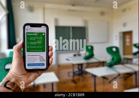 Mani tiene smartphone con l'applicazione di avvertimento Corona in TURCO in classe, Corona Crisis, Germania Foto Stock