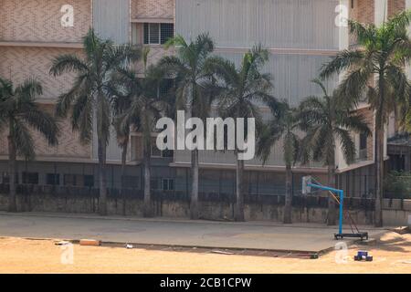 Mumbai, Maharashtra, India - Marzo 2020: Alberi di palma che frange un campo di pallacanestro in un campo universitario nella periferia di Mumbai. Foto Stock