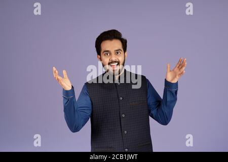 Ritratto di eccitato indiano che esprime gioia su sfondo lilla Foto Stock