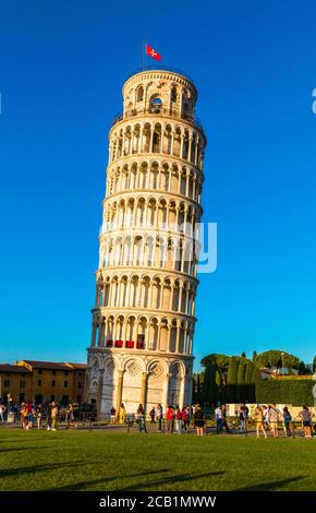 Un pittoresco ritratto della famosa Torre Pendente di Pisa in una bella giornata al tramonto con un cielo blu, e il sole splende sul bianco marmo... Foto Stock