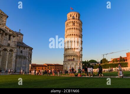 Bella vista dei turisti che ammirano la famosa Torre Pendente accanto alla cattedrale al tramonto in Piazza dei Miracoli a Pisa, Toscana, Italia. Il tutto... Foto Stock