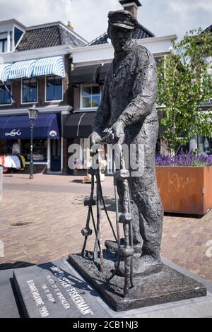 Statua in bronzo del De Lemster Fiskerman (pescatore) nel centro di Lemmer nei Paesi Bassi, creata da Bert Kiewiet Foto Stock