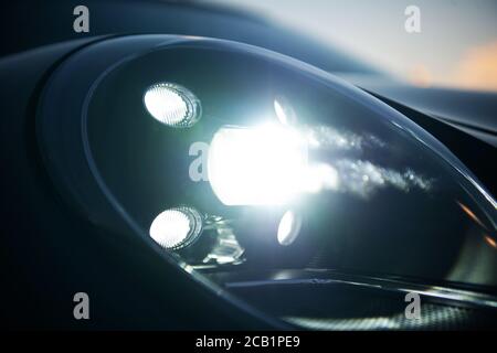 Faro anteriore a LED luminoso e lucido di notte per autovetture. Foto Stock