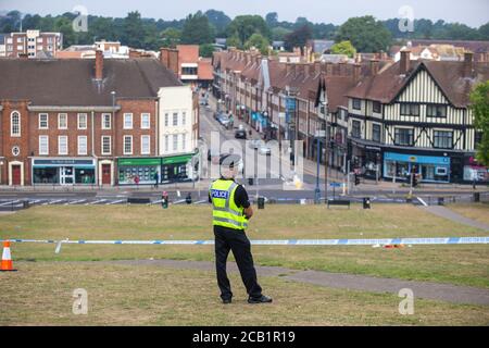 Il poliziotto si alza in guardia al cordone sulla scena del crimine che si affaccia sull'inglese città Foto Stock