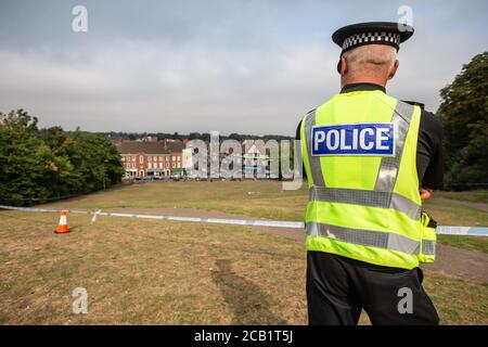 Il poliziotto si alza in guardia al cordone sulla scena del crimine che si affaccia sull'inglese città Foto Stock