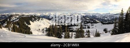 Montagne innevate e alberi. Incredibile paesaggio invernale panoramico innevato nelle Alpi all'alba. Stazione sciistica di Grasgehren, Allgau, Baviera, Germania Foto Stock