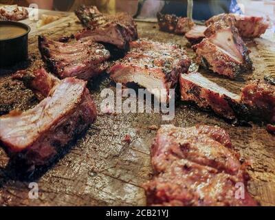 Costolette di maiale su un tagliere di legno. Primo piano di carne di maiale tagliata pronta per mangiare su osso Foto Stock