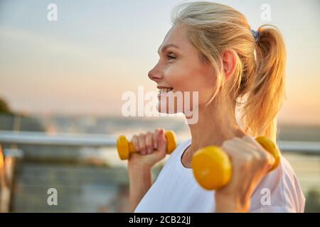 Soddisfatta atleta matura che si allena all'aperto Foto Stock