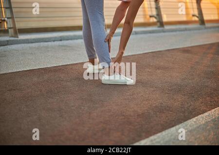 Donna sportiva e flessibile che esegue una curva in avanti Foto Stock