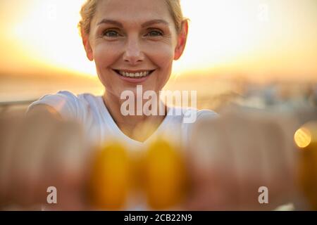 Donna allegra e forte che lavora con pesi Foto Stock