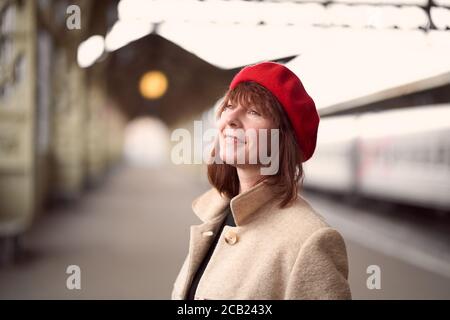 Primo piano ritratto di bella donna, in attesa di treno sulla stazione ferroviaria. La ragazza viaggia leggero. Foto Stock