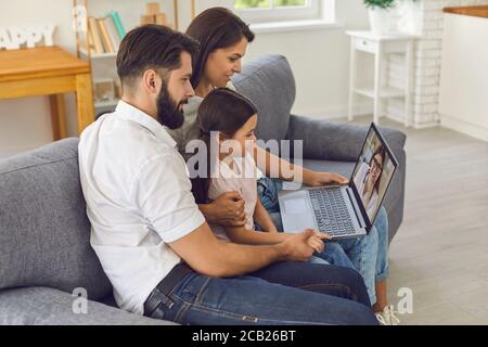 Medico di famiglia online. Buone consulti con la famiglia utilizzando un computer per videoconferenza a casa. Foto Stock