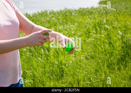 la ragazza sul lago usa uno spray contro le zanzare Foto Stock