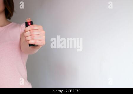 la ragazza tiene uno spray al pepe autodifesa Foto Stock