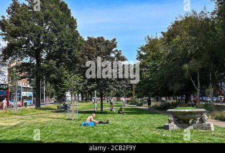 Brighton UK 10 agosto 2020 - i bevitori di strada in primo piano godono del sole caldo nella zona recentemente rinnovata dei Giardini della Valle di Brighton mentre le temperature raggiungono ancora gli anni 30 in parti del Sud Est: Credit Simon Dack / Alamy Live News Foto Stock