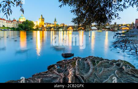 Fiume Moldava e Ponte Carlo illuminato di sera. Praga, Repubblica Ceca. Foto Stock