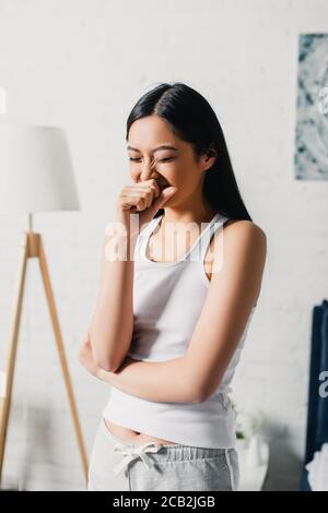 Giovane donna asiatica che urla di mattina a casa Foto Stock