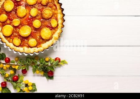 Torta aperta di pasta frolla con prugna di ciliegia, clafoutis di prugna mirobalana su sfondo bianco Foto Stock