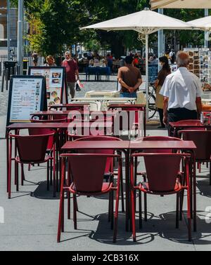 I camerieri si trovano di fronte alle terrazze vuote del ristorante in attesa dei clienti a Lisbona, Portogallo Foto Stock