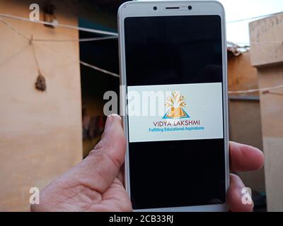 DISTRICT KATNI, INDIA - 23 MAGGIO 2020: Donna che tiene uno smartphone con il logo del portale vidya lakshmi visualizzato sullo schermo. Partito al governo indiano sta Foto Stock