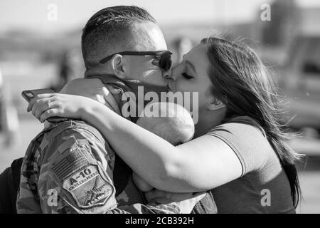 Una maschera COVID non ferma un bacio domestico di benvenuto come gli Airmen della 124th Fighter Wing tornano a casa dallo schieramento, 8 agosto 2020, a Boise, Idaho. (STATI UNITI) Foto Stock