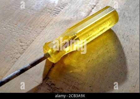 manico giallo traslucido sul vecchio cacciavite Foto Stock