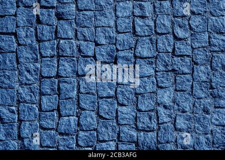 Vista dall'alto su una strada in pietra da vicino. Vecchio pavimento di granito. Marciapiede di ciottoli quadrato blu. Mock up o vintage grunge texture.Trendy Banner con colore Foto Stock