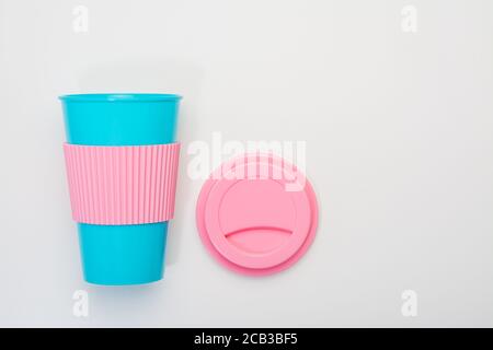Tazza blu riutilizzabile con rivestimento in silicone rosa e coperchio per caffè, bevande calde e fredde Foto Stock