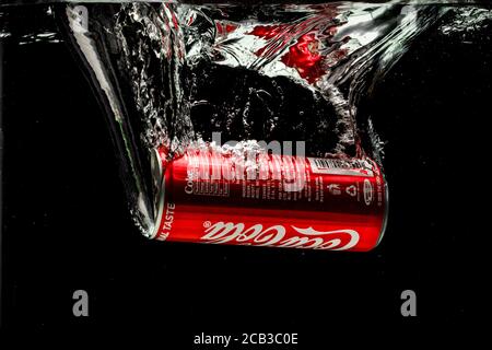 Coca cola può spruzzare in acqua su sfondo nero Foto Stock