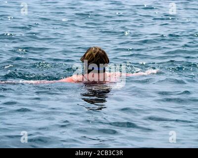 Donna nuotare nel mare Foto Stock